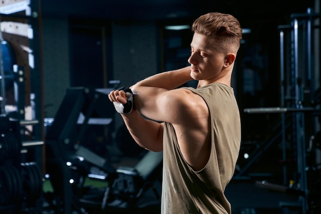 Bodybuilder étirant les bras dans la salle de gym