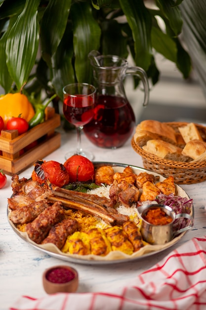 Boeuf, brochette de poulet, barbecue avec pommes de terre rôties et grillées, tomates et riz