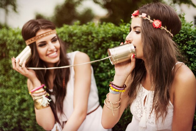 Boho femmes parlant par téléphone en boîte de conserve