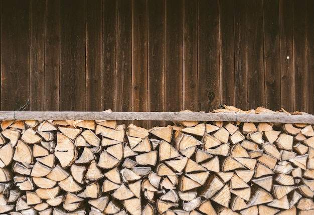 Photo gratuite bois de chauffage empilé devant une cabane en bois dans les alpes bavaroises.