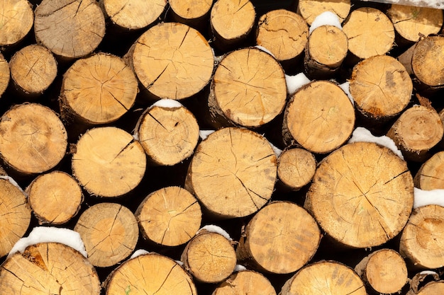 Bois recouvert de neige prêt pour le chauffage. Rustique et vintage