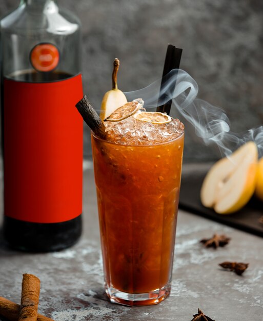 Boisson froide à la poire avec des bâtons de cannelle