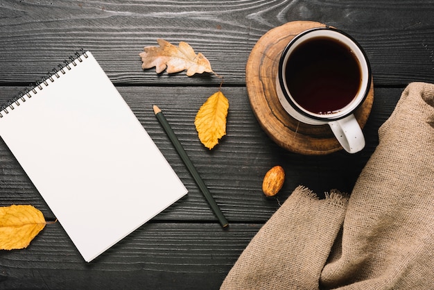 Photo gratuite boisson et tissu près des feuilles et de la papeterie