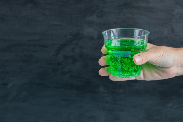 Photo gratuite boisson verte dans la main avec des bulles d'eau à l'intérieur