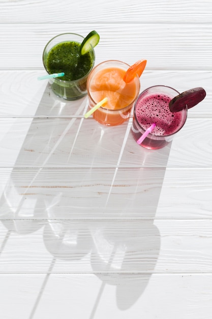 Boissons colorées dans des verres sur une table en bois