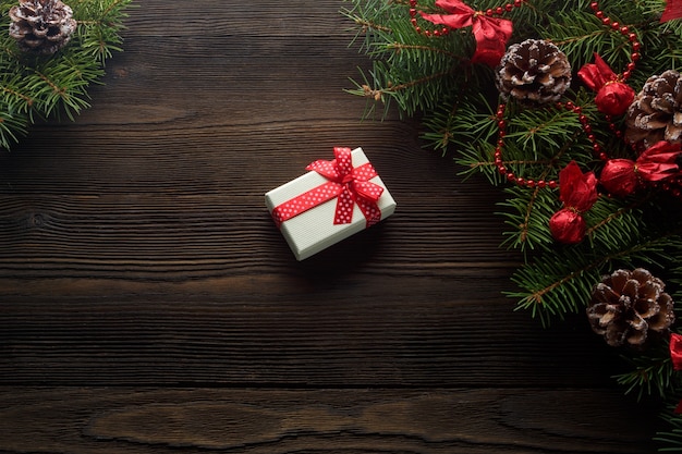 Boîte blanche avec un arc rouge sur une table en bois avec ornement de Noël