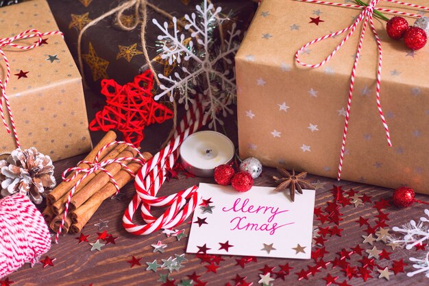 Boîte de cadeau de vacances de Noël avec carte postale joyeux Noël sur la table de fête décorée