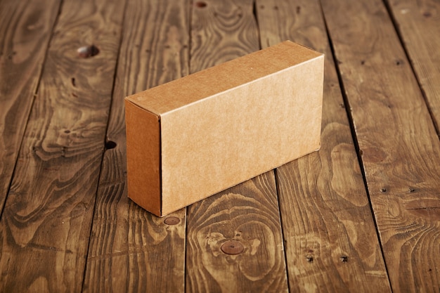 Boîte d'emballage en carton artisanal présenté sur table en bois brossé stressé