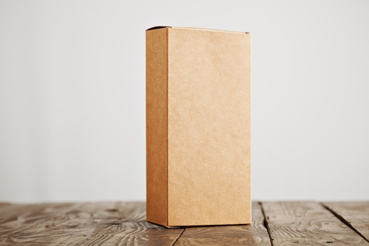 Photo gratuit boîte d'emballage en carton artisanal présenté verticalement sur table en bois brossé stressé, isolé sur fond blanc