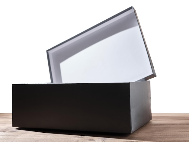 Boîte ouverte noire sur table avec fond isolé