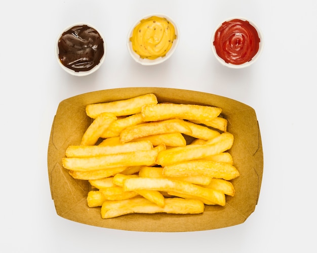 Boîte plate de frites avec des sauces