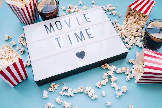 Photo gratuite boîte à pop-corn avec une pancarte de cinéma