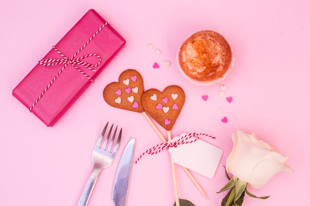 Boîte présente près de gâteaux, de fleurs et de biscuits sur des baguettes