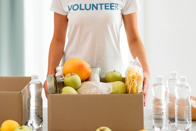 Photo gratuite boîte de tenue de bénévole avec de la nourriture pour le don