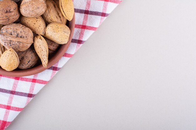 Bol d'amandes et de noix bio décortiquées sur fond blanc. Photo de haute qualité