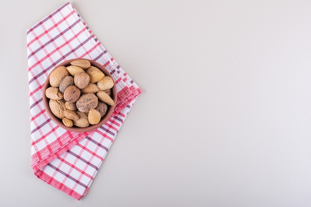 Bol d'amandes et de noix biologiques décortiquées sur fond blanc. photo de haute qualité