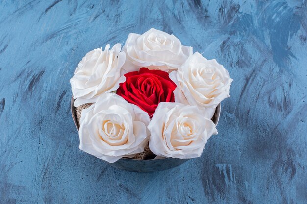 Un bol ancien avec de belles roses fraîches blanches et rouges.