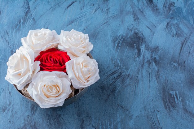 Un bol ancien avec de belles roses fraîches blanches et rouges