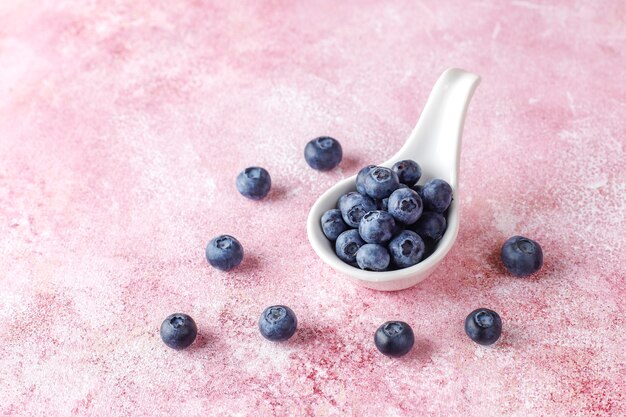 bol blanc de délicieux bleuets mûrs sur une surface en marbre