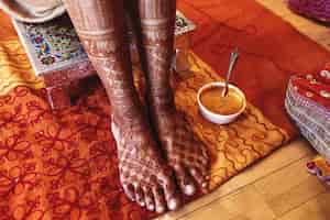 Photo gratuite bol blanc avec de la pâte de curcuma se trouve sous la mariée indienne