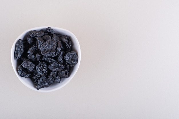 Bol Blanc De Prunes Séchées Placées Sur Fond Blanc. Photo De Haute Qualité