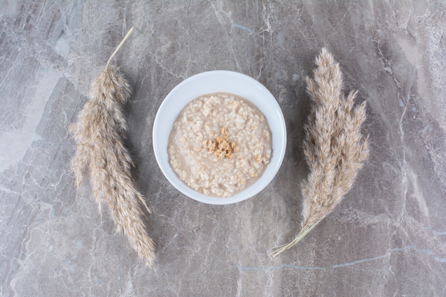 Un bol blanc avec une savoureuse bouillie d'avoine saine pour le petit-déjeuner.