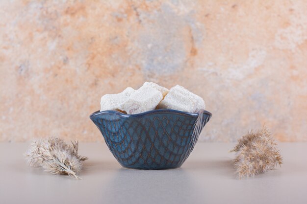 Bol bleu de desserts sucrés aux noix sur fond blanc. photo de haute qualité