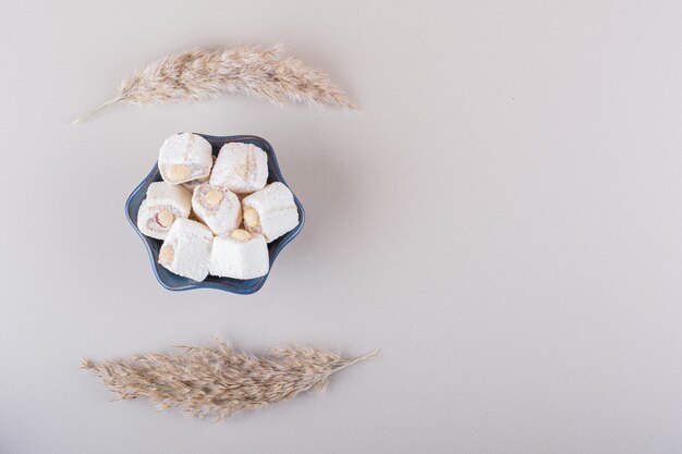 Bol bleu de desserts sucrés aux noix sur fond blanc. photo de haute qualité