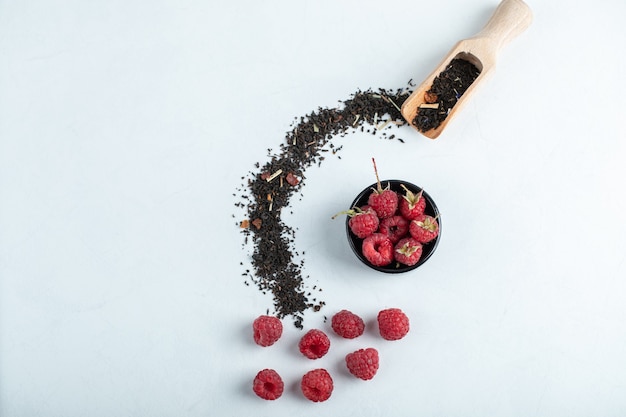 Bol En Bois De Framboises Avec Cuillère De Thé Noir Sec Sur Pierre