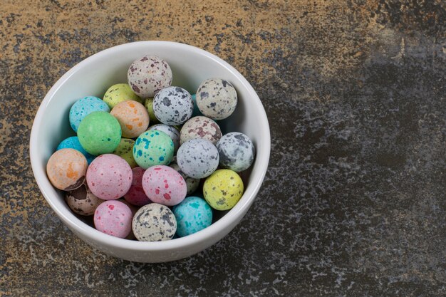 Bol de bonbons colorés sur marbre.