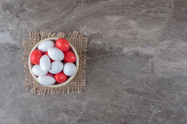 Un Bol De Bonbons Sur Le Dessous De Plat Sur La Surface En Marbre