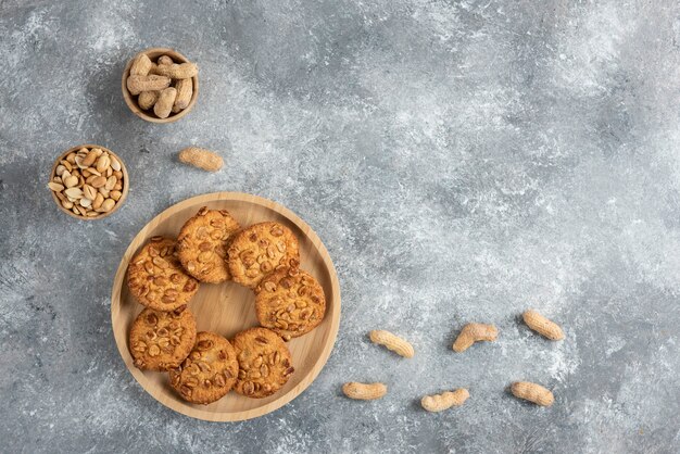 Bol de cacahuètes et biscuits aux cacahuètes biologiques sur table en marbre.