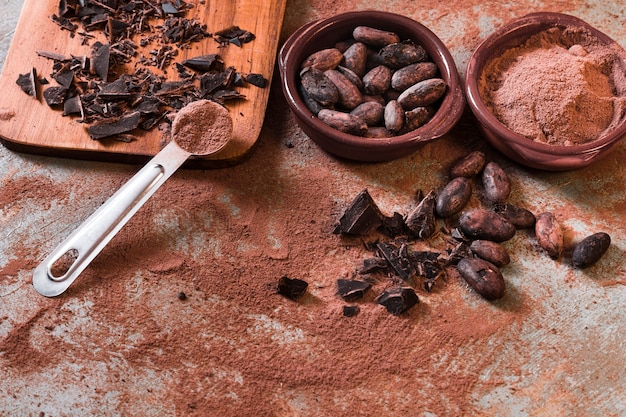 Bol cassé de fèves au chocolat et cacao sur toile de fond rustique