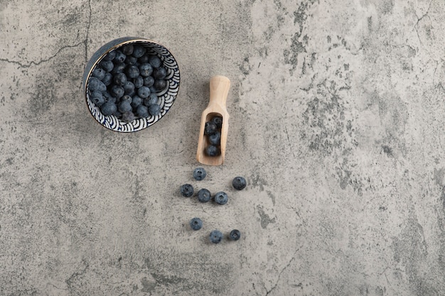 Bol en céramique de délicieux bleuets frais sur une surface en marbre