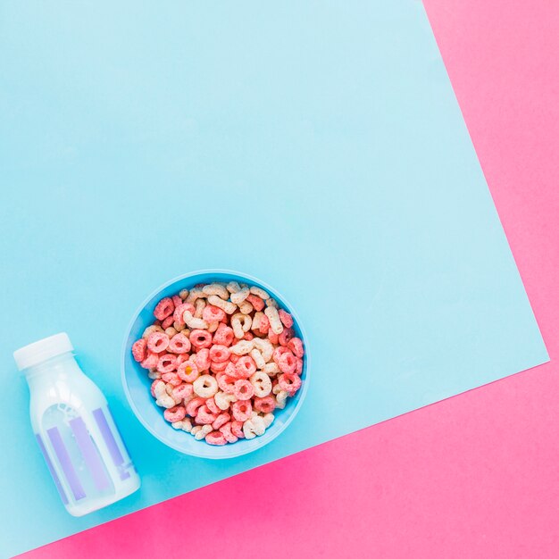 Bol de céréales et bouteille de lait bleu sur table