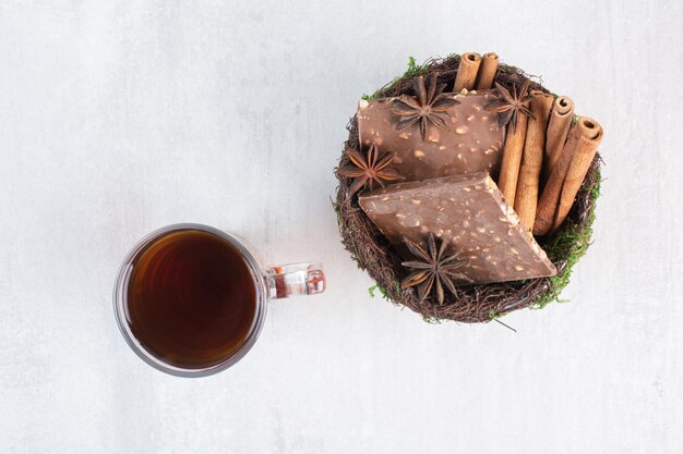 Bol de chocolat aux noix et cannelles avec verre de thé