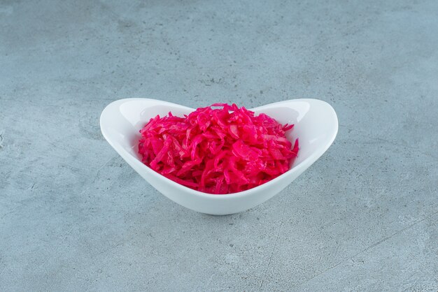 Un bol de choucroute fermentée rouge sur la surface bleue