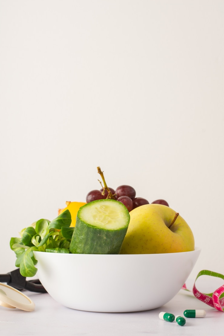 Photo gratuit bol avec concombre et délicieuse pomme sur la table