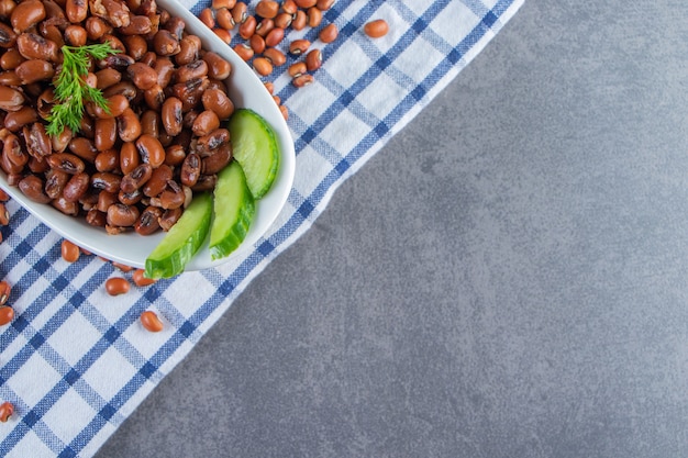 Photo gratuite bol de concombre et haricots en tranches sur une serviette, sur le fond de marbre.