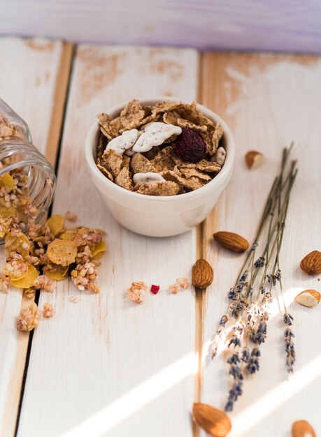 Bol, cornflakes, près, renversé, pot, de, granola, et, fruits secs, sur, surface bois