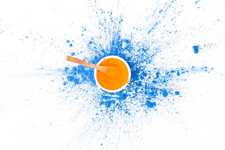 Photo gratuit bol avec cuillère et couleur orange sur des couleurs sèches bleues