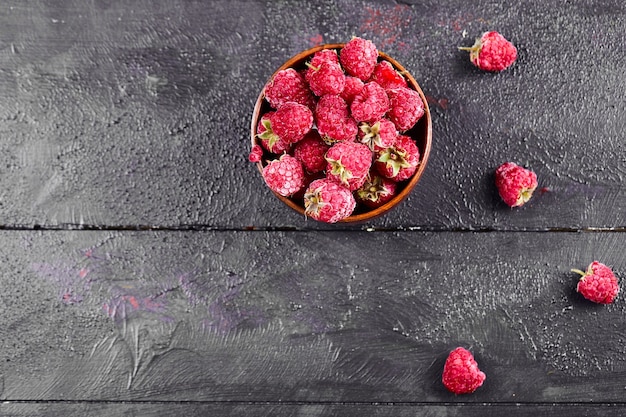 Photo gratuite bol de framboises rouges fraîches sur table en bois foncé.