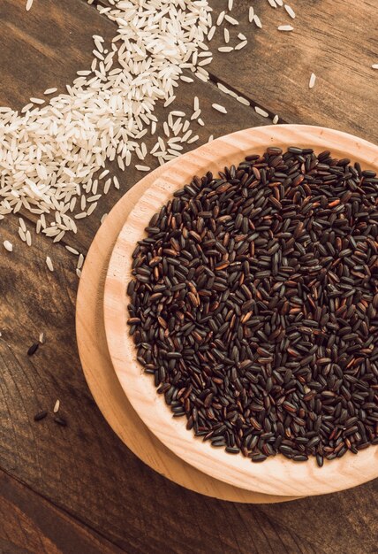 Bol de grain de riz biologique brun avec du riz blanc sur table