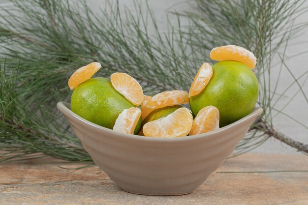 Bol de mandarine fraîche et segments sur table en marbre.