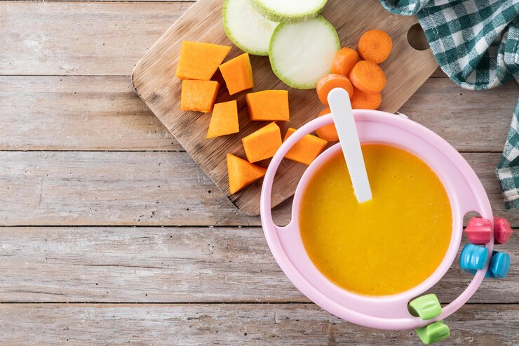 Photo gratuit un bol avec de la nourriture pour bébé, de la purée de légumes sur une table en bois.