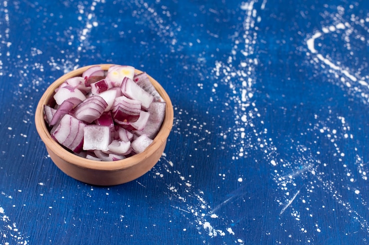 Photo gratuit bol d'oignons violets frais tranchés sur une surface en marbre