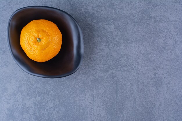 Un bol d'oranges, sur la surface sombre