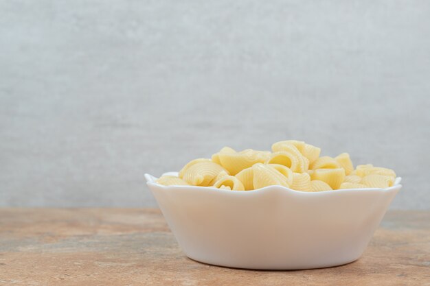 Bol de pâtes en forme de coquillage sur table en marbre