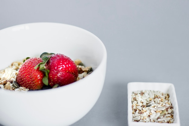 Photo gratuite bol de petit-déjeuner avec des flocons d'avoine et des fraises