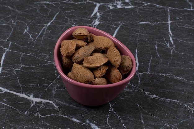 Photo gratuite bol plein d'amandes, sur la surface en marbre